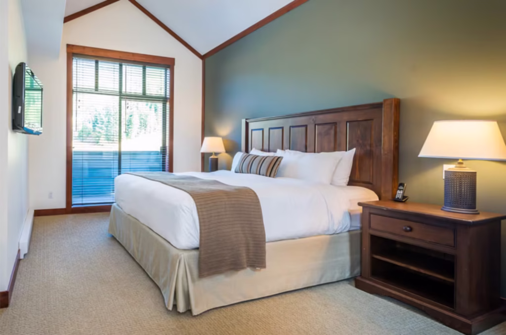 King Bed In Bedroom At First Tracks Lodge Whistler Hotel