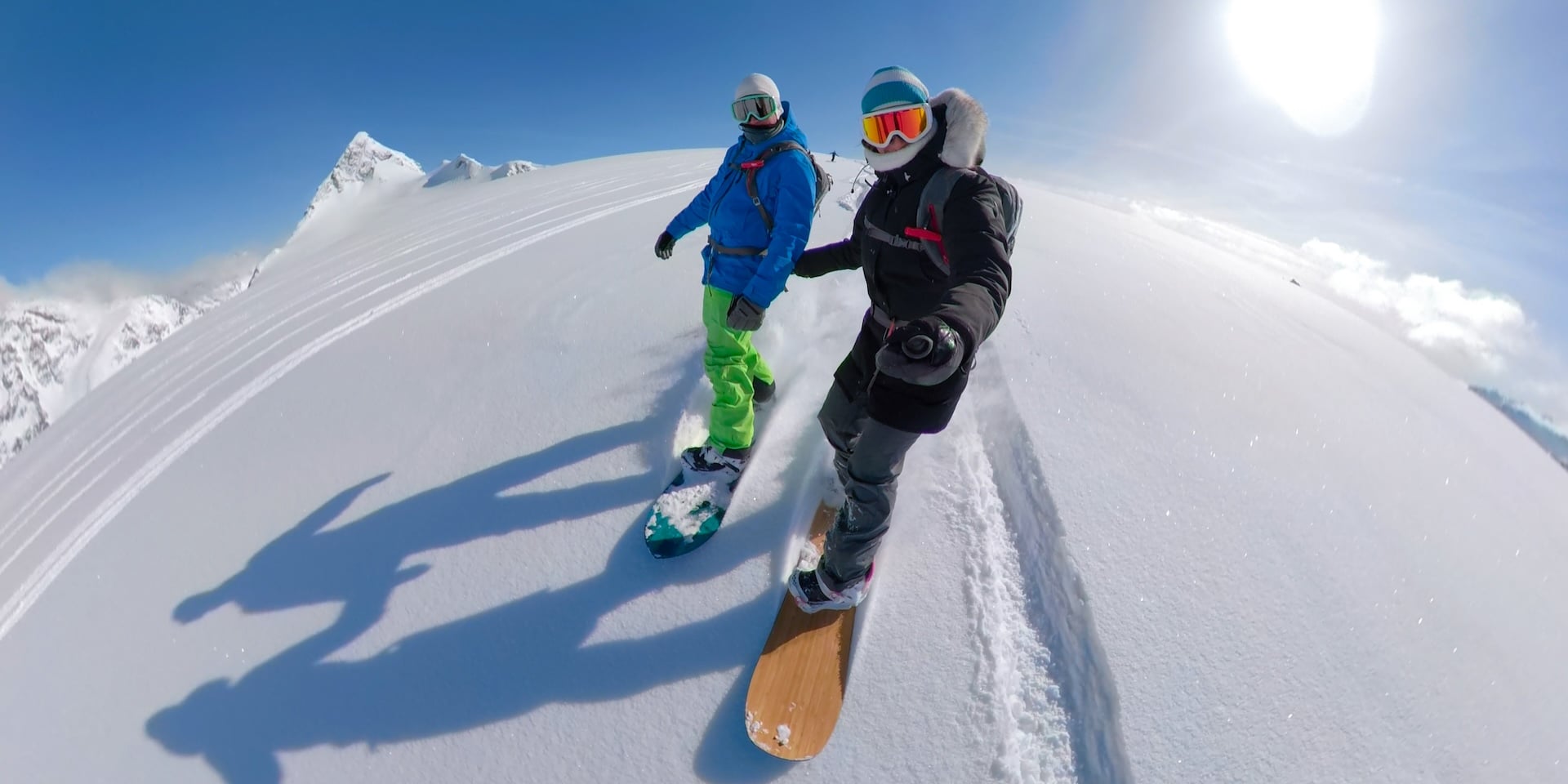 Young Couple On Fun Active Winter Vacation In Stunning Whistler, British Columbia Snowboarding Together Off Piste On A Sunny Day.